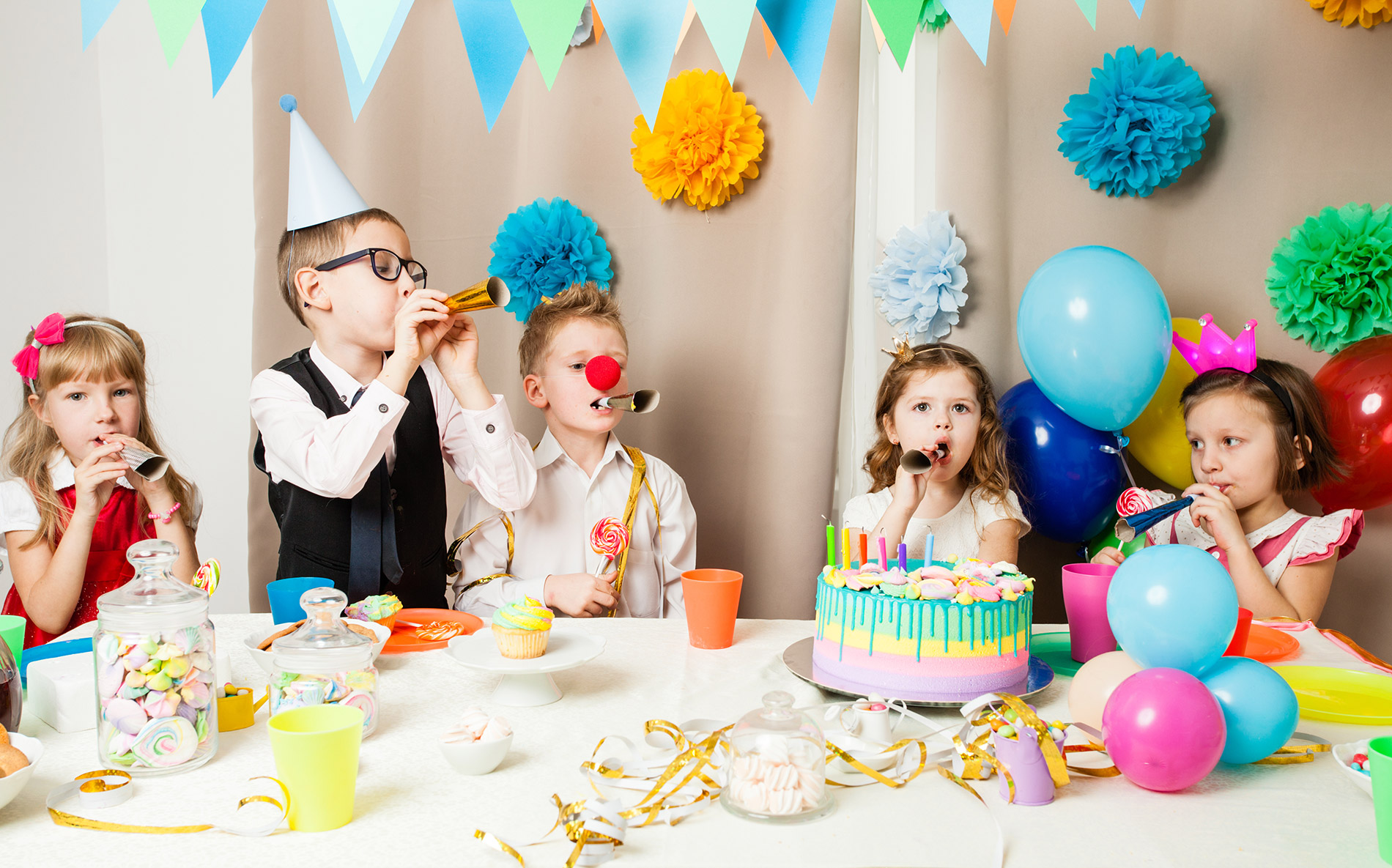 3 children at a party with a cake